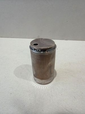 une poubelle argentée posée sur une surface blanche
