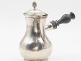 une théière en argent avec une anse noire sur un fond blanc