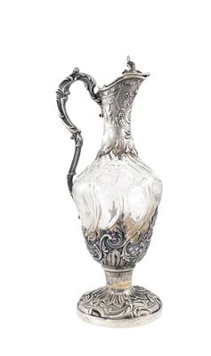 a silver and glass vase with a handle on a stand