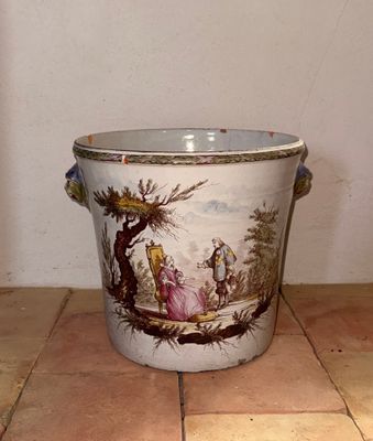 un pot décoré d'une peinture, posé sur un sol carrelé