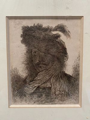 an old picture of a man with a feathered headdress in a white frame