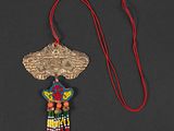 a close up of a necklace on a black surface with a red string