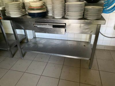 beaucoup d'assiettes empilées sur une table dans la cuisine