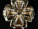 an image of a brooch with pearls on it on a black surface
