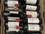 Les bouteilles de vin se trouvent dans un carton posé sur une table.