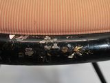 a close up of a chair with a pink cushion on it