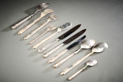 Plusieurs fourchettes et cuillères sont disposées en rangée sur une table