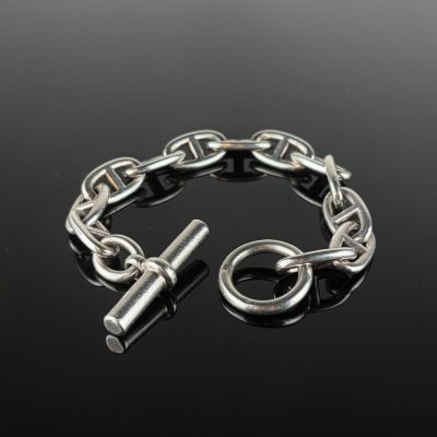 un gros plan d'un bracelet à maillons muni d'un fermoir, posé sur une surface noire