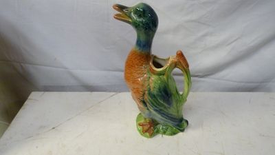 un petit canard en céramique posé sur une table