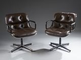 une paire de fauteuils de bureau en cuir marron à roulettes, dans un studio