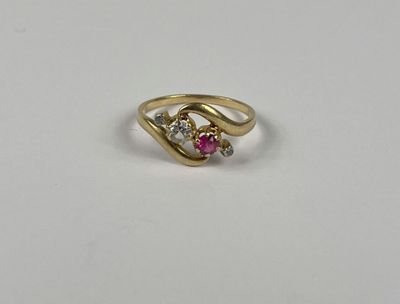 un gros plan d'une bague en or sertie d'une pierre rose et blanche