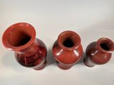three vases that are sitting on a white surface