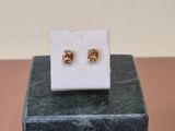 a close up of a pair of earrings sitting on top of a marble block