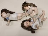 three dolls that are laying on the floor together
