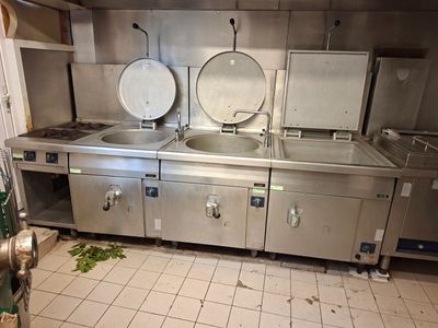 une grande cuisine avec de nombreux appareils en acier inoxydable