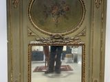 un grand miroir orné d'une peinture, placé au milieu d'une pièce