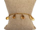 un gros plan sur un oreiller sur lequel repose un bracelet en or
