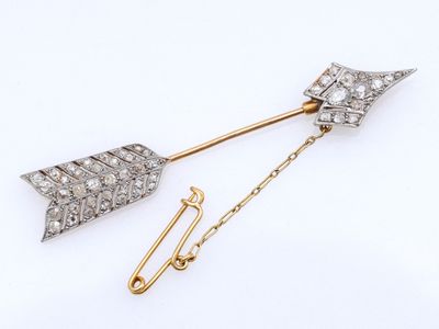 une broche en forme de flèche en diamant et en or
