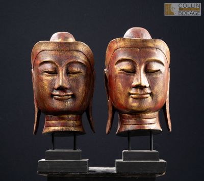 deux statues en bois représentant des visages de Bouddha sur fond noir