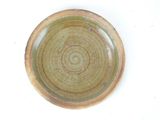 a brown plate with a green rim on a white surface