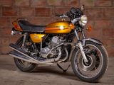 a yellow motorcycle parked in front of a brick wall