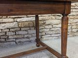 a wooden table that is sitting in front of a brick wall