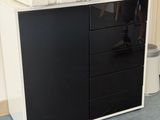 a black and white cabinet with drawers and a printer on top