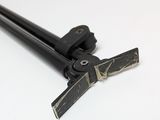 a black pole with a wooden handle on a white surface