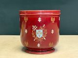 un vase rouge orné d'un blason