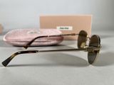 chanel sunglasses with gold details and a pink case on a table