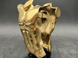 brass horse head sculpture on black base on grey background