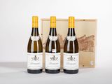 trois bouteilles de vin sont posées devant une caisse en bois