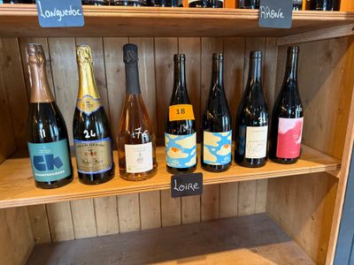 de nombreuses bouteilles de vin sur une étagère dans un magasin