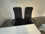 two black chairs sitting next to each other in a room