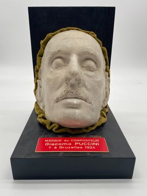 un gros plan sur une sculpture représentant une tête d'homme posée sur un socle