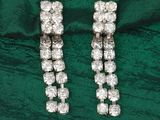 deux paires de boucles d'oreilles en diamant posées sur un fond de velours vert