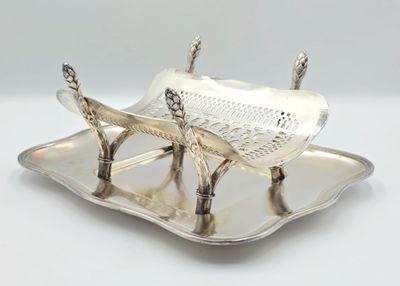 une assiette en argent sur laquelle est représenté un poisson, sur un fond blanc