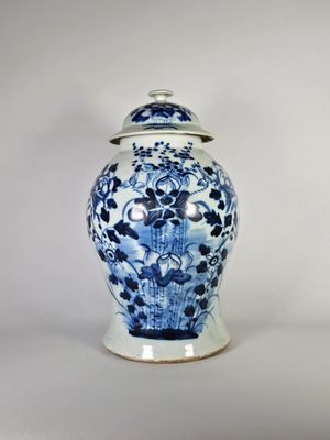 un vase bleu et blanc avec un couvercle posé sur une table