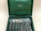 a green case with silverware in it on a white surface