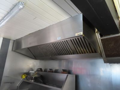 a kitchen with a stainless steel stove top and a vent hood