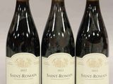 trois bouteilles de vin sont alignées sur une table