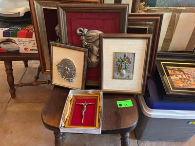 de nombreuses photos encadrées et une croix posée sur une table