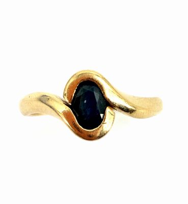 a close up of a gold ring with a blue stone