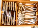 de nombreuses fourchettes et cuillères dans une boîte posée sur la table