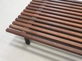 a wooden bench that is sitting on a white floor