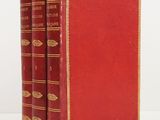three red books sitting on top of each other on a white surface