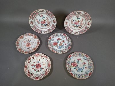 six small plates with floral designs on them sitting on a table