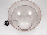 a glass bowl with a spoon in it on a white surface