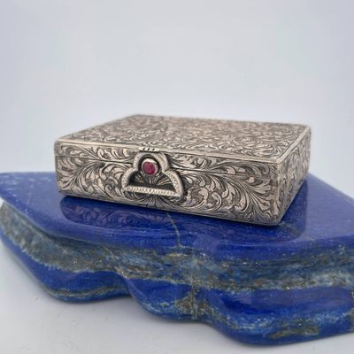 a silver box sitting on top of a blue rock