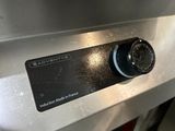 a close up of a silver oven with a button on it